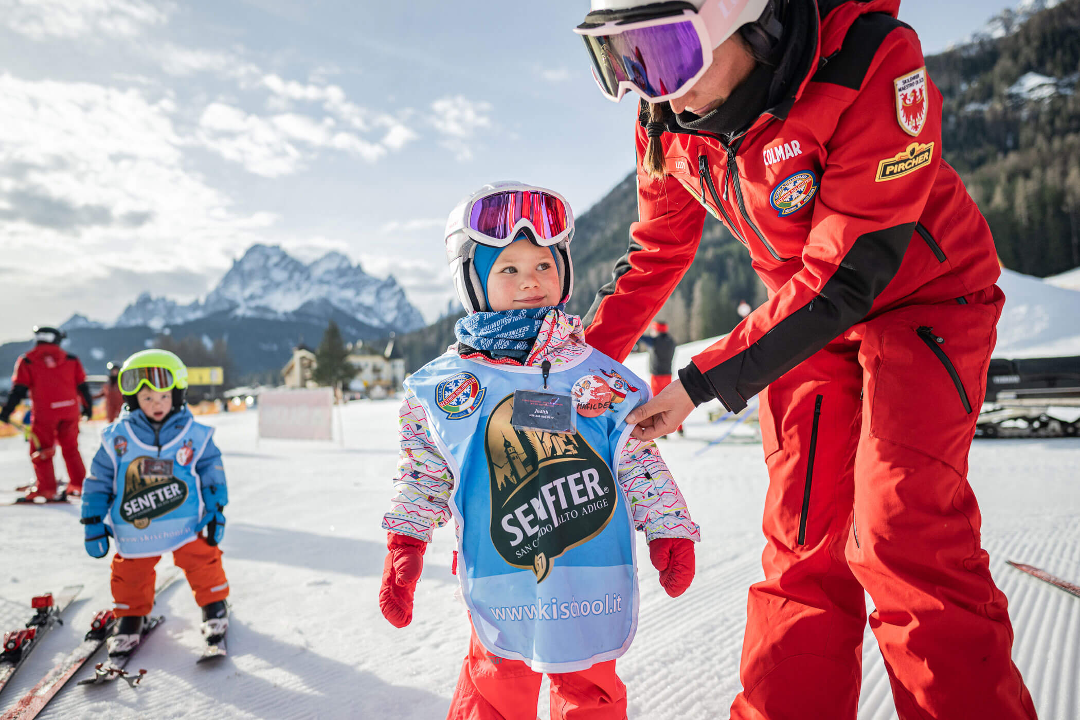 Skilehrerin richtet die Kleidung ihrer Schülerin - SkiSchule Sexten