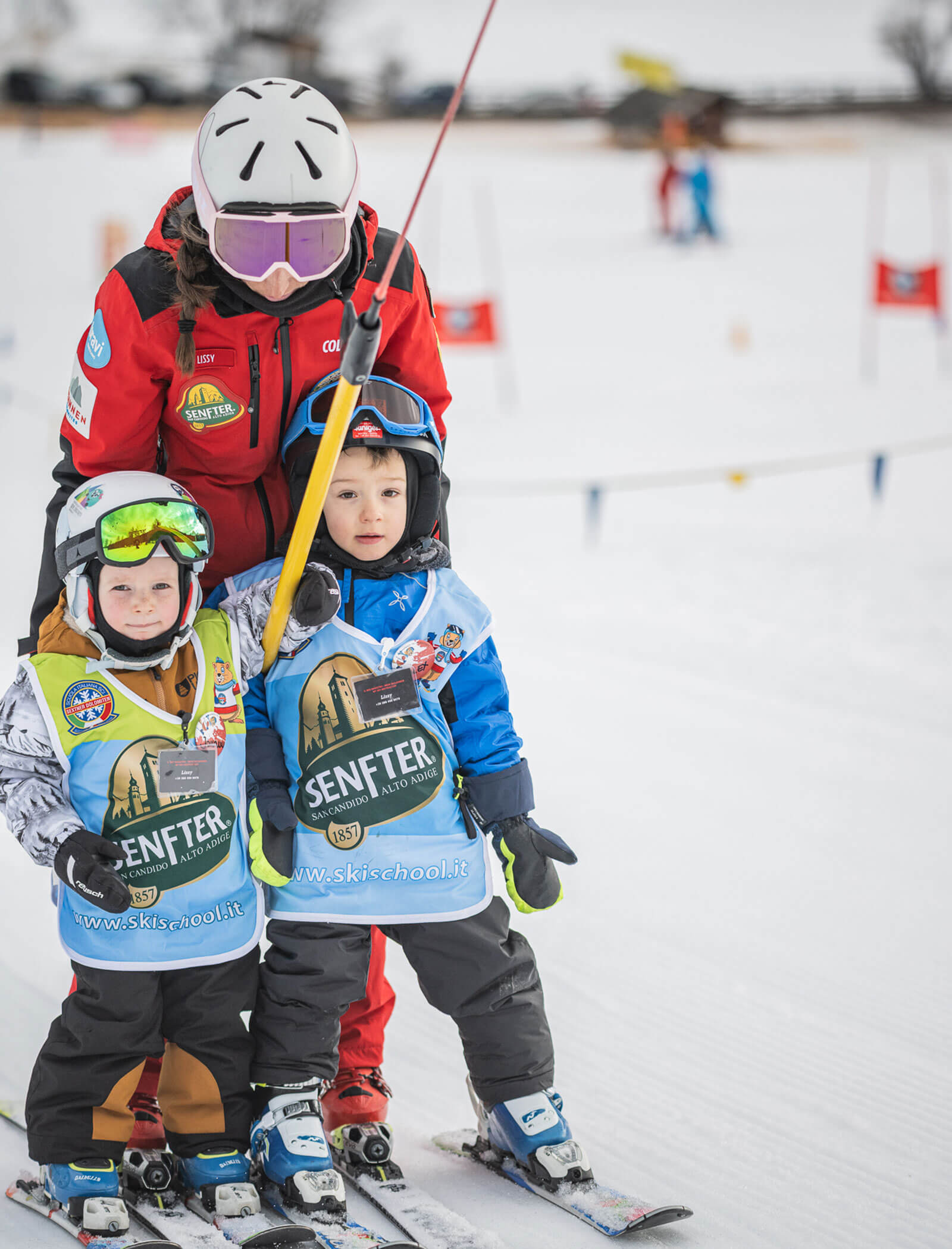 Maestra di sci con due bambini sull'impianto di risalita - ScuolaSci Sesto
