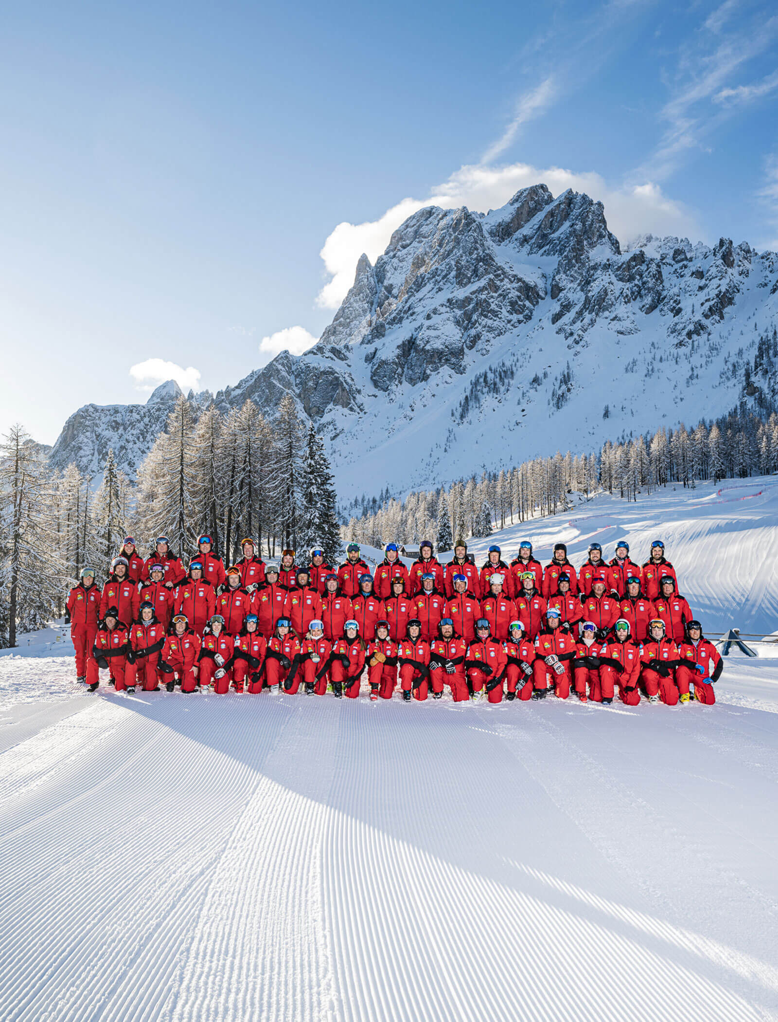 Tutti i membri e lo staff davanti a una montagna innevata - ScuolaSci Sesto